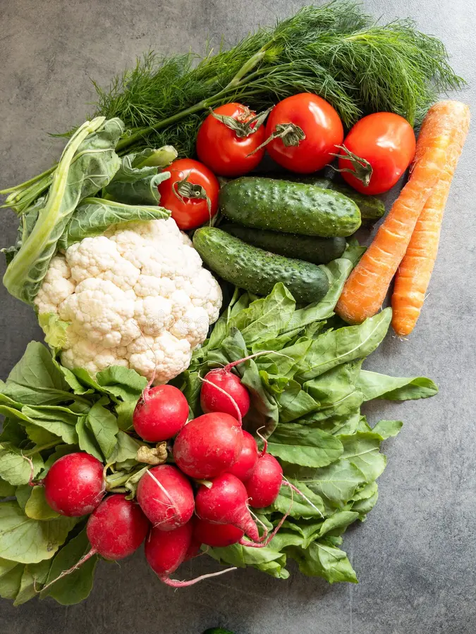 Färska grönsaker och enkla råvaror ordnade på en köksyta i naturligt ljus